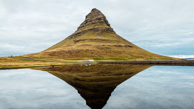 De puntige berg Kirkjufell weerspiegeld in een stil meer op het schiereiland Snæfellsnes