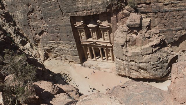 De Schatkamer (Al-Khazneh) van Petra van bovenaf gezien, met het plein en de rotswanden van de Siq