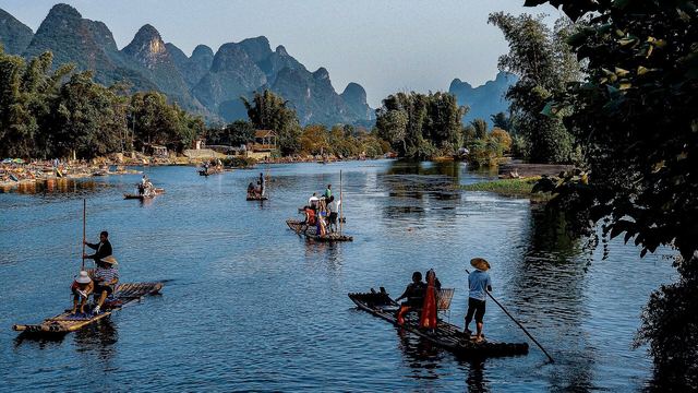 Een bamboevlot op de Yulong rivier tussen karstbergen